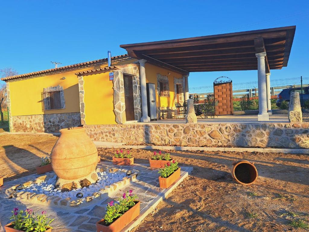 a house with a large vase and some plants at Casa Rural La Veguilla in Argés
