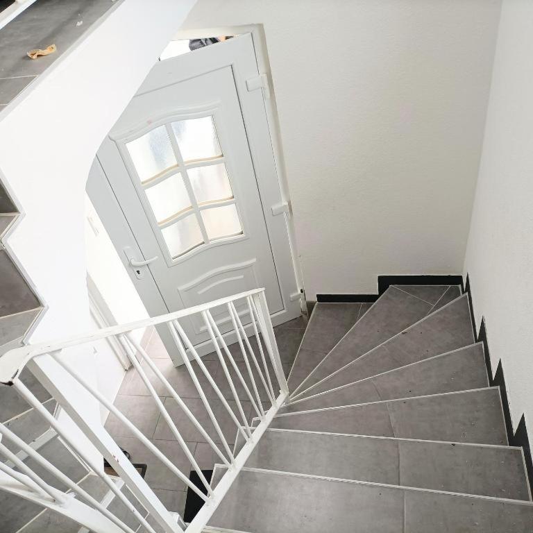 een trap met een witte deur en een raam bij Hattersheim 3 Room Apartment in Hattersheim