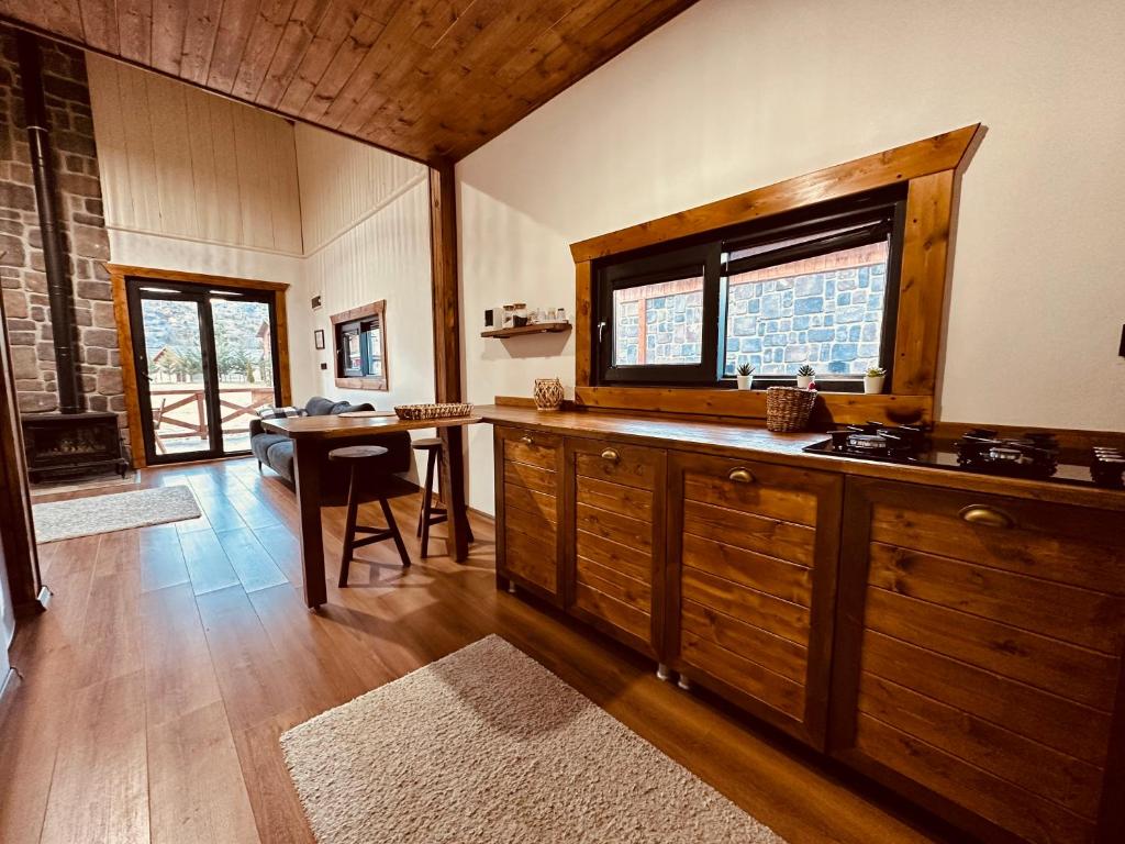 een keuken met houten kasten en een tafel en een raam bij Haremi Garden Suit Bungalovs 