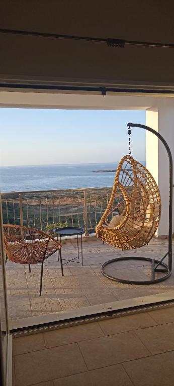 a rattan chair and a bench on a balcony at Casa Lazareta in Chania