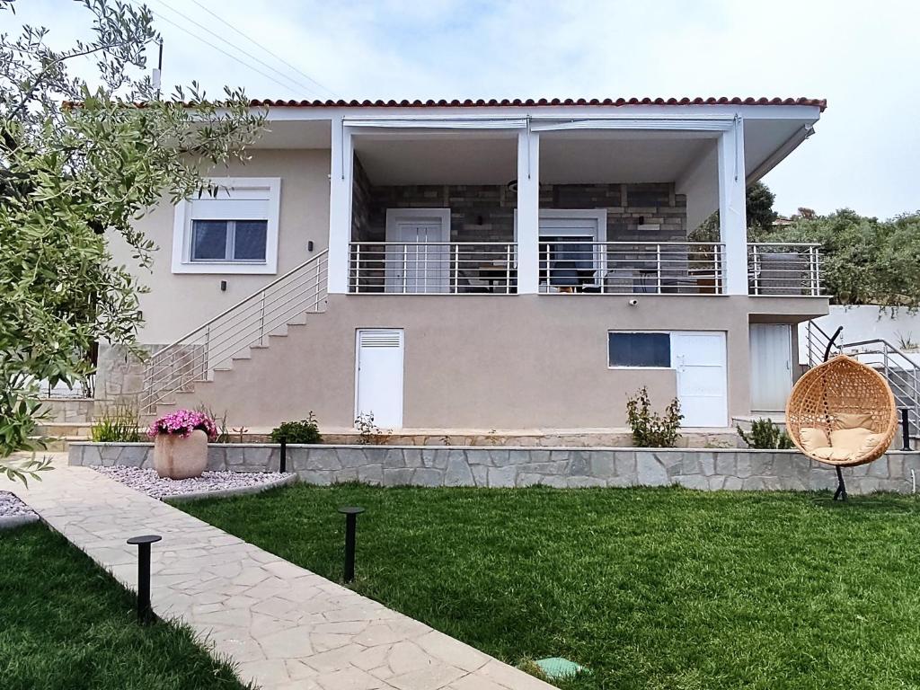een huis met een balkon en een tuin bij Villa Alexandra in Elevtheraí