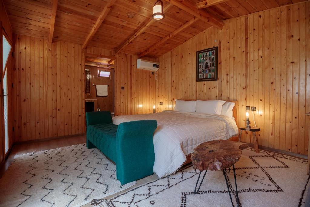 a bedroom with a bed and a green chair at Dar l'eau Vive in Bine el Ouidane