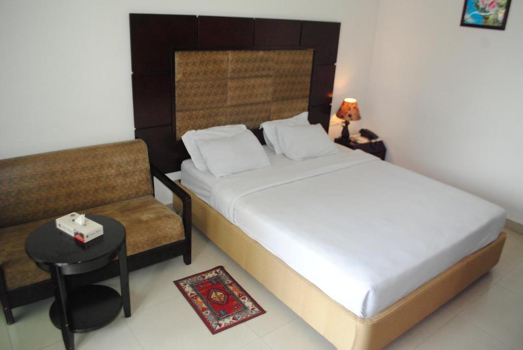 1 dormitorio pequeño con 1 cama y 1 silla en Hotel Mishuk, en Cox's Bazar