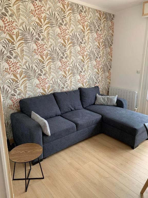 - un canapé bleu dans le salon avec un mur dans l'établissement Le Solemare Appartement T3 Face Mer Cayeux sur Mer, à Cayeux-sur-Mer