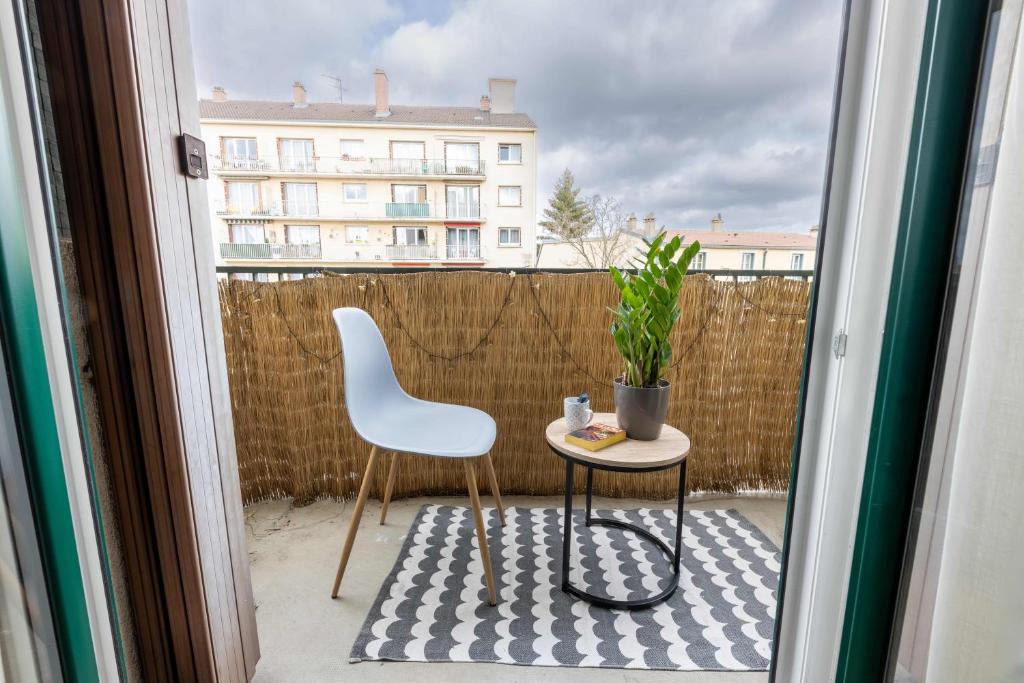 une chaise et une table avec une plante sur un balcon dans l'établissement Confort à 10 minutes de la Gare de Lyon, à Maisons-Alfort