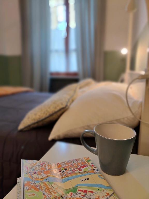a cup of coffee sitting on a table with a book at Ca' di Rosy in Ivrea