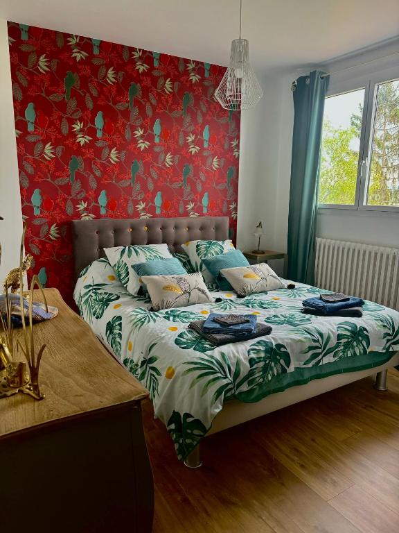 - une chambre dotée d'un lit avec un mur rouge dans l'établissement Suite alcôve confort, à Freneuse