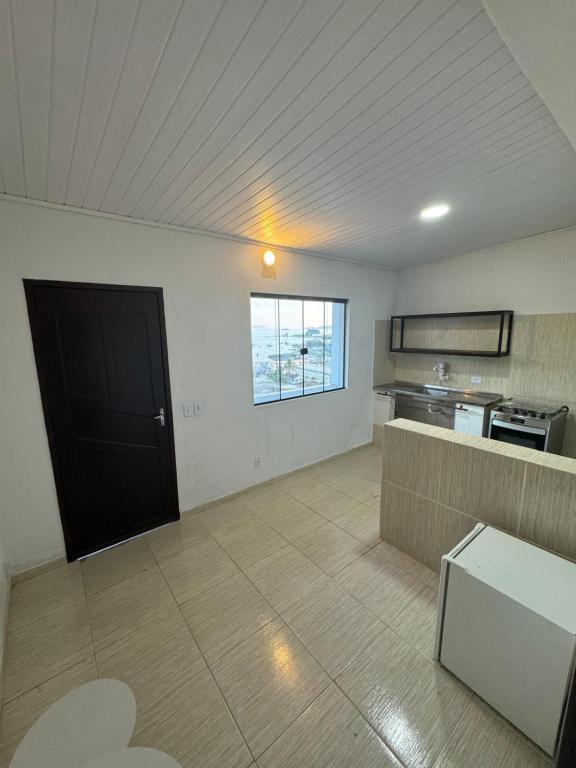 an empty room with a kitchen and a black door at Casa Bela Vista in Angra dos Reis