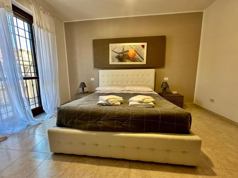 ein Schlafzimmer mit einem großen Bett in einem Zimmer mit Fenstern in der Unterkunft Casa Cecilia(Villino da 2 a 8 persone) in Ladispoli