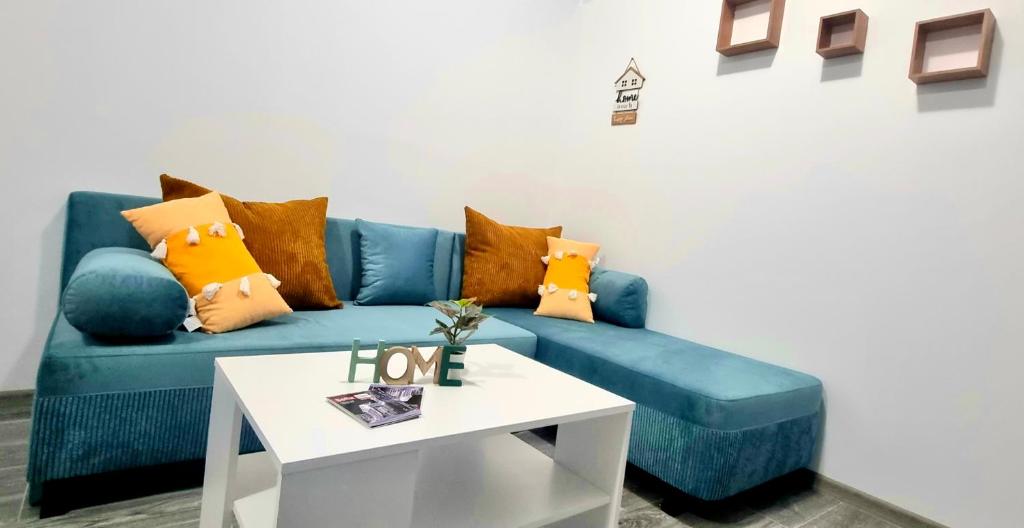 a blue couch with pillows and a table in a room at Lazy loft in Sofia