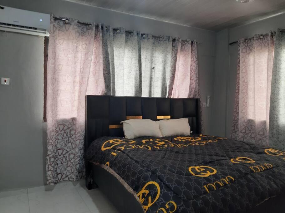 a bedroom with a bed with a black and gold bedspread at The Alpha residence in Tema