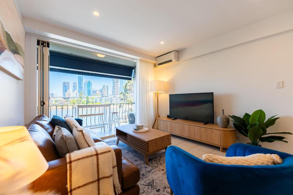 a living room with a couch and a television at Riverside 2 bedrooms apartment w view in Brisbane