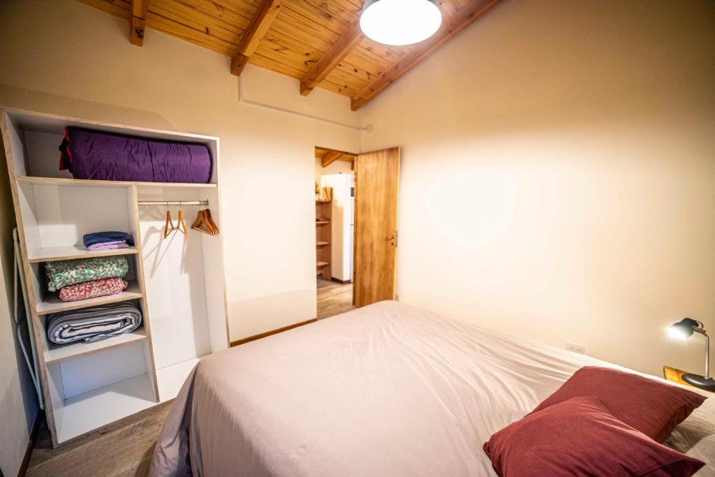 1 dormitorio con cama y armario en Casa en entorno de bosque, cerca de playas y cerros en San Carlos de Bariloche