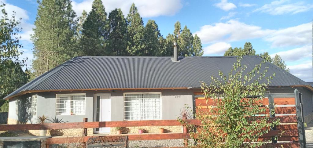 une maison avec une clôture devant elle dans l'établissement Chalet Liwen, à San Martín de los Andes