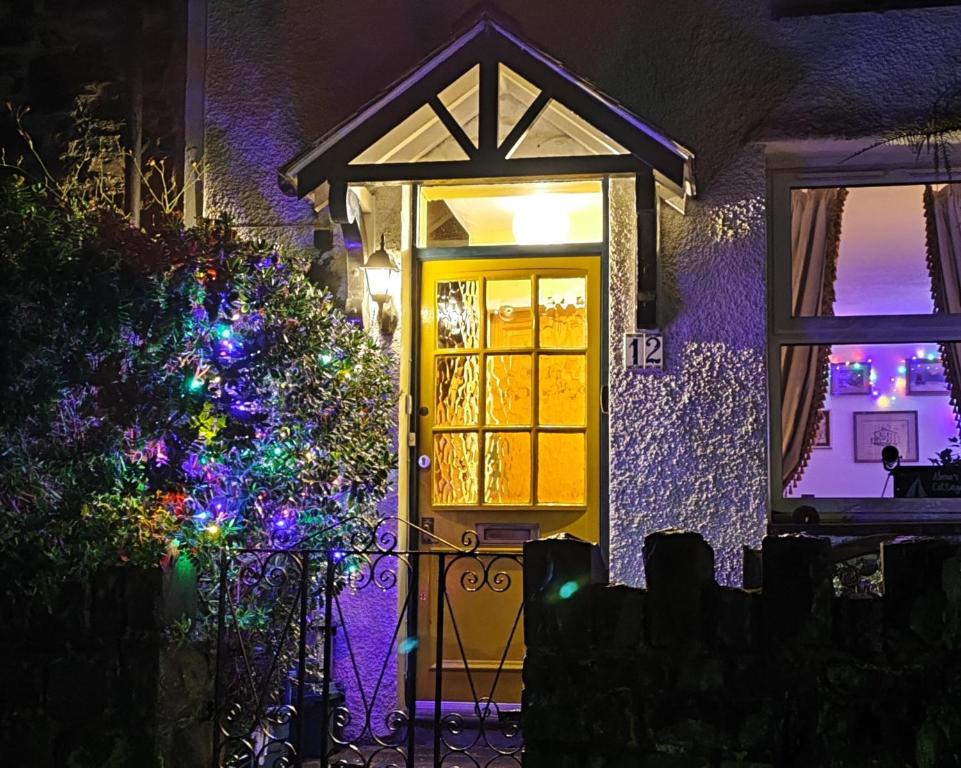 a front door of a house with christmas lights at Alma's Cottage at Penmaenmawr in Penmaen-mawr