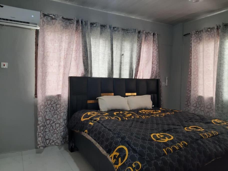 a bedroom with a bed with a black and gold bedspread at The Alpha* residence in Tema