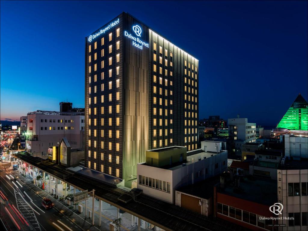 a tall building with lights on it in a city at Daiwa Roynet Hotel Aomori in Aomori