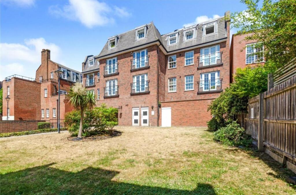 an empty yard in front of a large brick building at Entire Apartment in London in Bromley