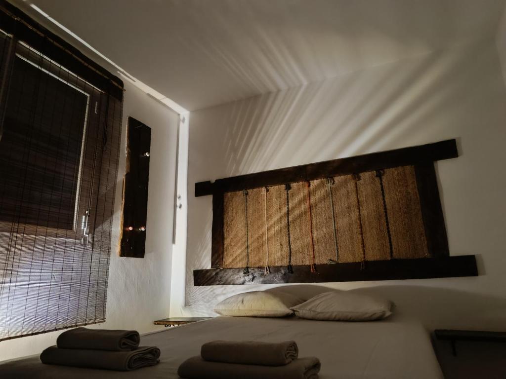 a bedroom with a bed with two pillows and a window at Casa rural la luz de Ari in Traspinedo