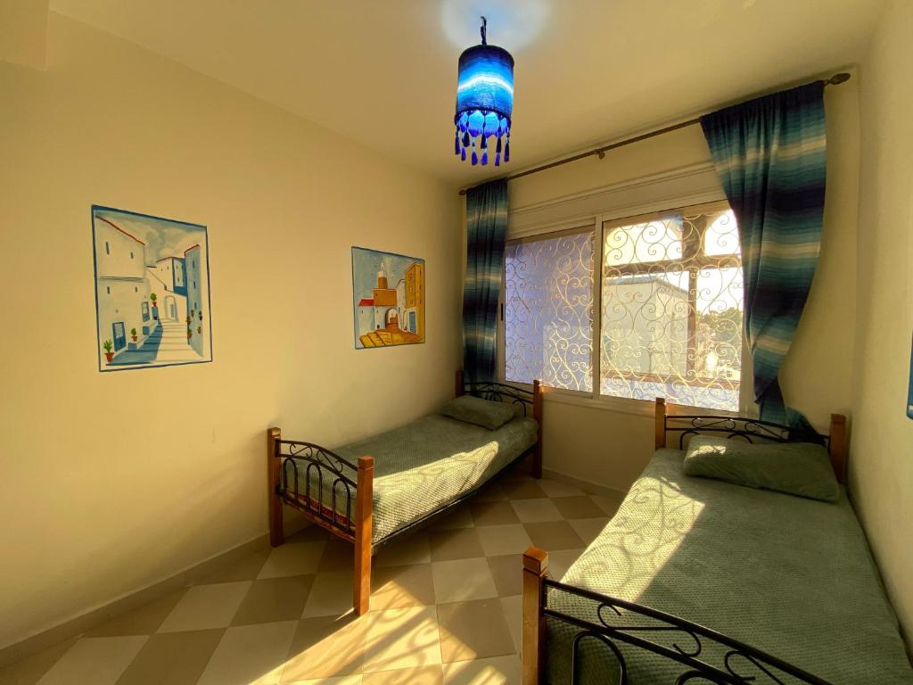 a bedroom with two bunk beds and a window at House blue pearl chefchaouen in Chefchaouen