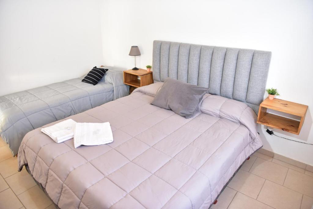 ein Schlafzimmer mit einem großen Bett mit zwei Handtüchern darauf in der Unterkunft Departamento x dia Viedma 4 CON COCHERA in Viedma