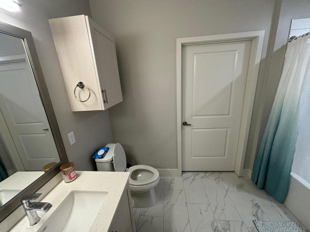 baño con aseo, lavabo y puerta en InMotion, en San Diego