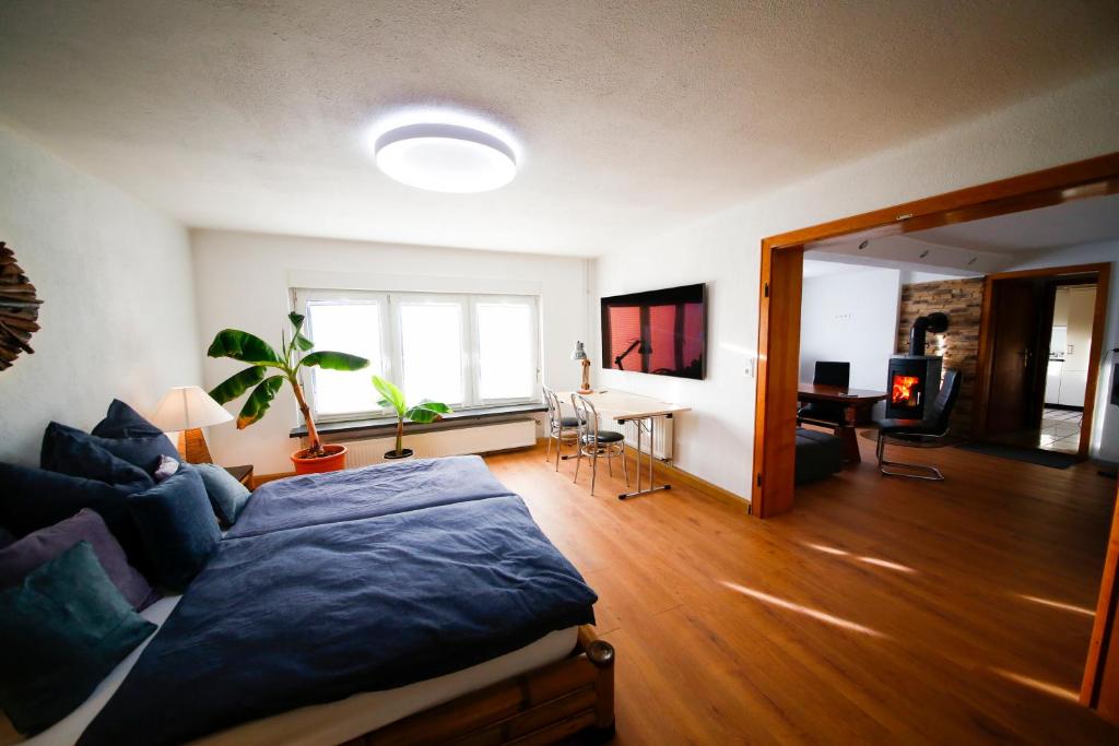 a bedroom with a bed and a living room at Schlossberg Apartments & Garten in der Natur & unweit vom "Thüringer Meer" in Unterwellenborn