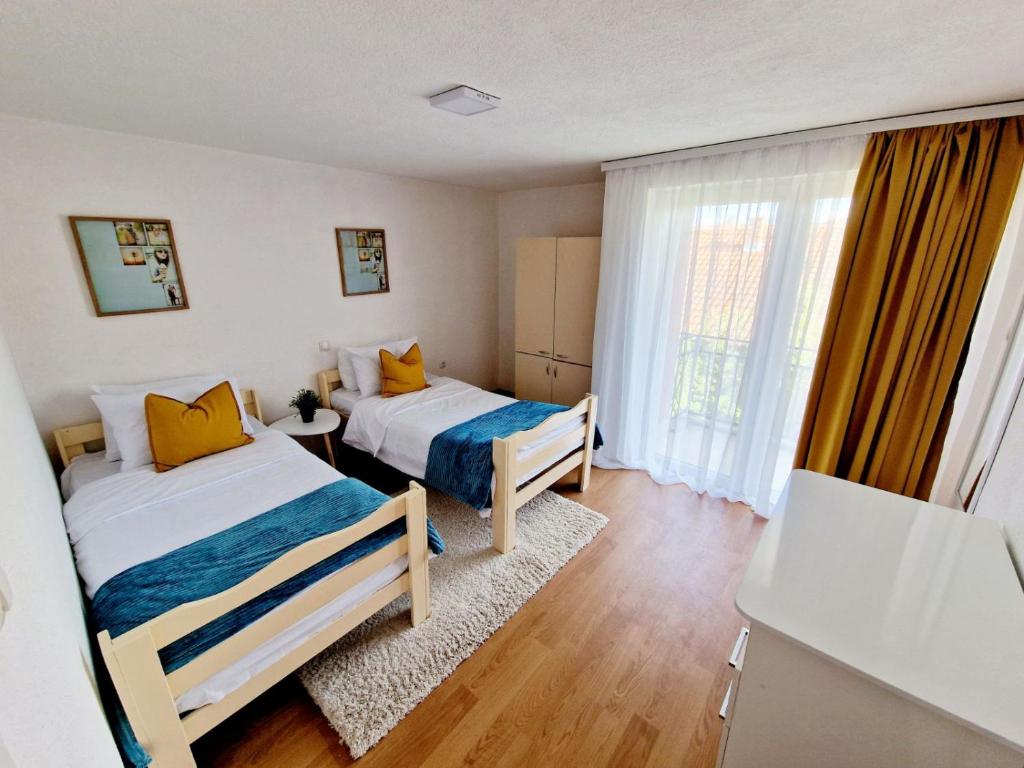 een slaapkamer met 2 bedden en een raam bij Serenity Apartment in Bitola
