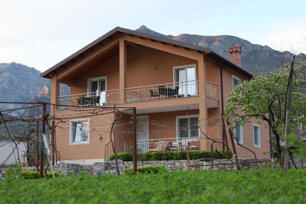 una casa en una colina con montañas en el fondo en koman_lakeview_apartments, en Shkodër