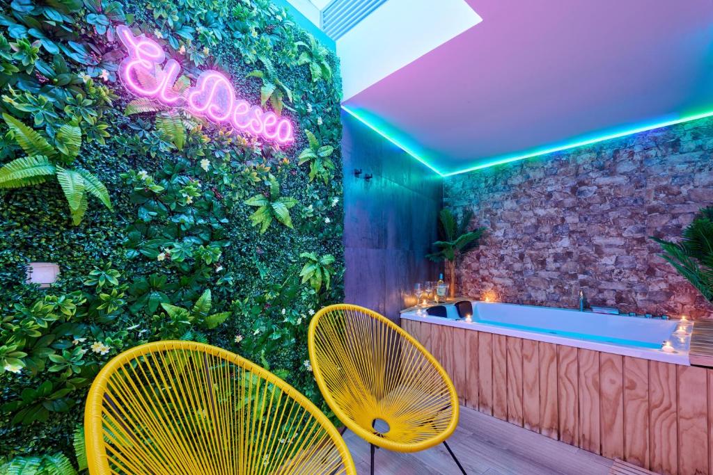 蘇西羅斯的住宿－El Deseo，浴室设有绿色墙壁、浴缸和2把黄色椅子