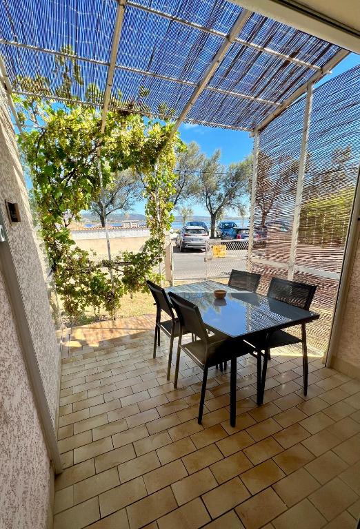 un patio avec une table et des chaises dessus dans l'établissement Maison de vacances à la plage, à Frontignan