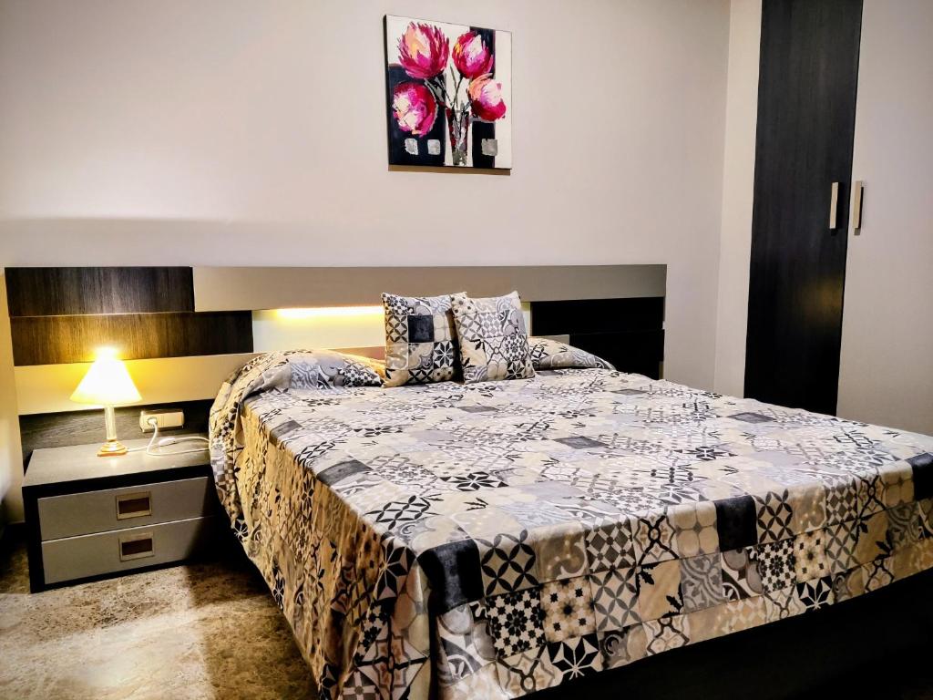 una camera con letto e tavolo con lampada di Apartamento El Rincón del Parque a Baena