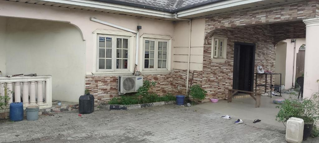 un patio de una casa con una pared de ladrillo en Doris Lounge en Port Harcourt