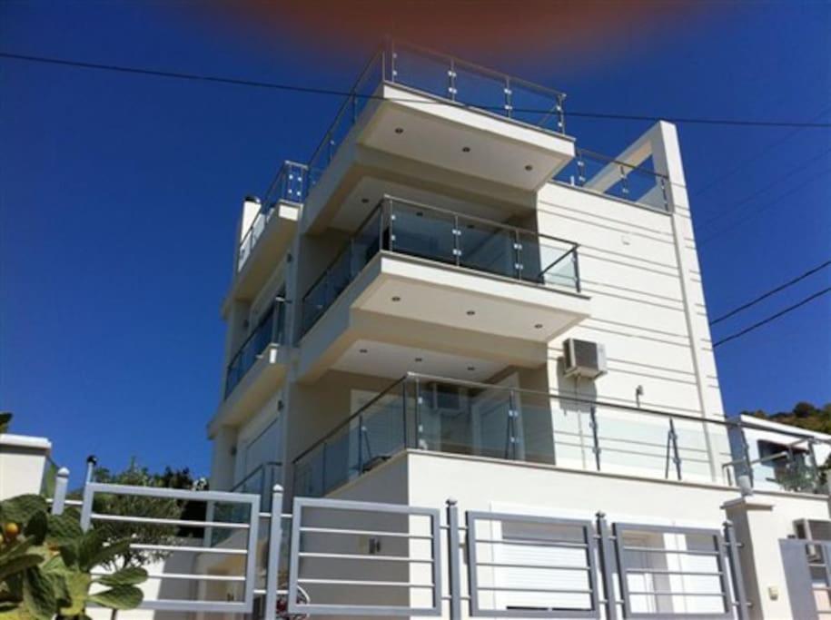- un bâtiment blanc avec des balcons sur le côté dans l'établissement Beautiful lux Villa Ilias Salamina, à Salamine