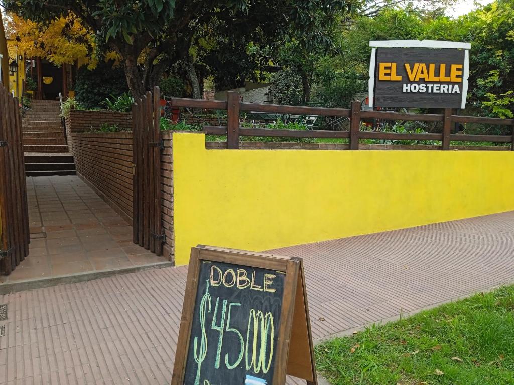un mur jaune avec un signe indiquant que la dolésie est seizième dans l'établissement El Valle Hostería, à Mina Clavero