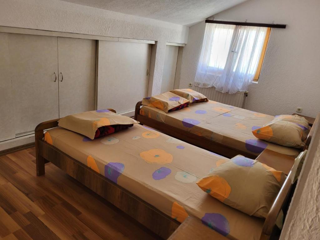 a bedroom with two beds and a window at Vreshtat e Liqenit-Ezerski Llozja in Struga