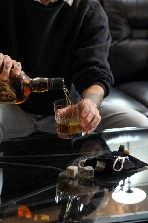 a person pouring a drink into a glass on a table at The Landmark Inn on Orcas Island in Eastsound