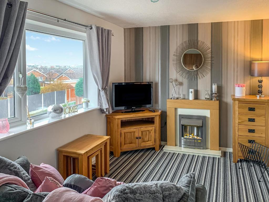 a living room with a tv and a fireplace at Sunny Rhyl Apartment - Uk44631 in Rhyl