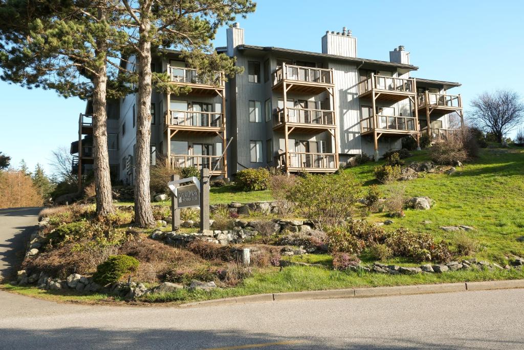 duży budynek apartamentowy na wzgórzu z drzewami w obiekcie The Landmark Inn on Orcas Island w mieście Eastsound