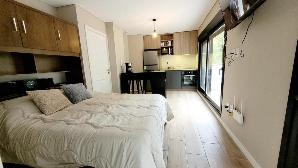 1 Schlafzimmer mit einem großen Bett und einer Küche in der Unterkunft Hermoso apartamento con terraza! Punta Carretas in Montevideo