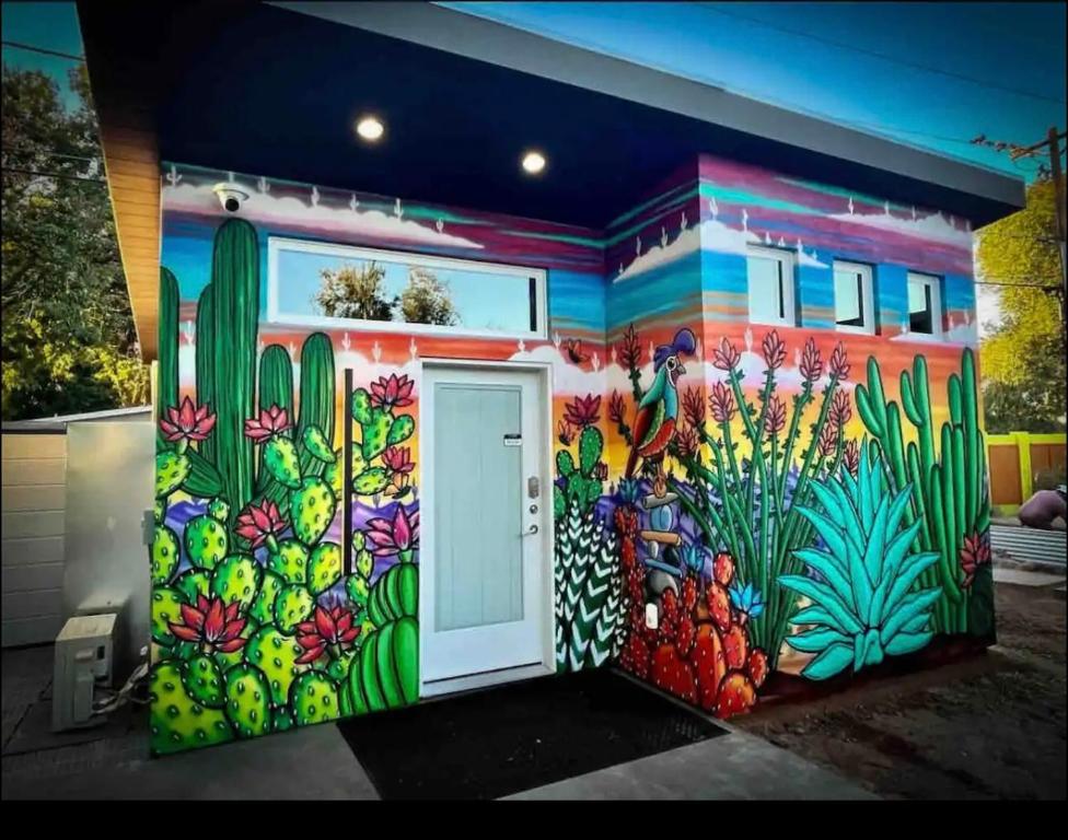 um mural no lado de um edifício com uma porta em Tiny House Centrally Located in Great Neighborhood em Phoenix