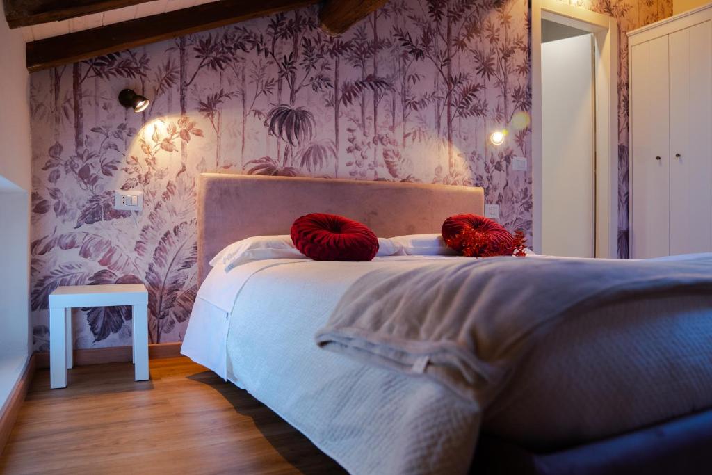 1 dormitorio con 1 cama con 2 almohadas rojas en Domus 44 Apartments, en Verona