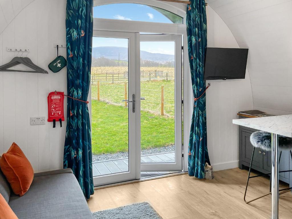 a living room with a sliding glass door at Bombie Glamping Pod in Cromdale
