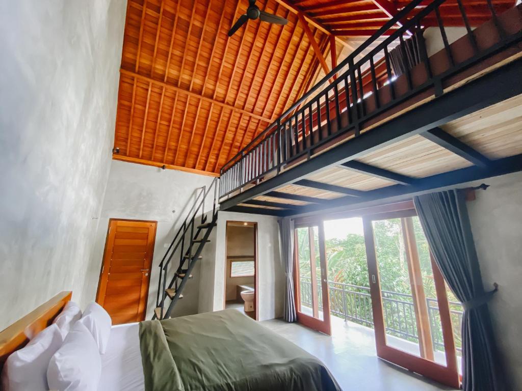 TampaksiringCountry Side Room in Taro Tegallalang的阁楼卧室设有一张床和一个楼梯