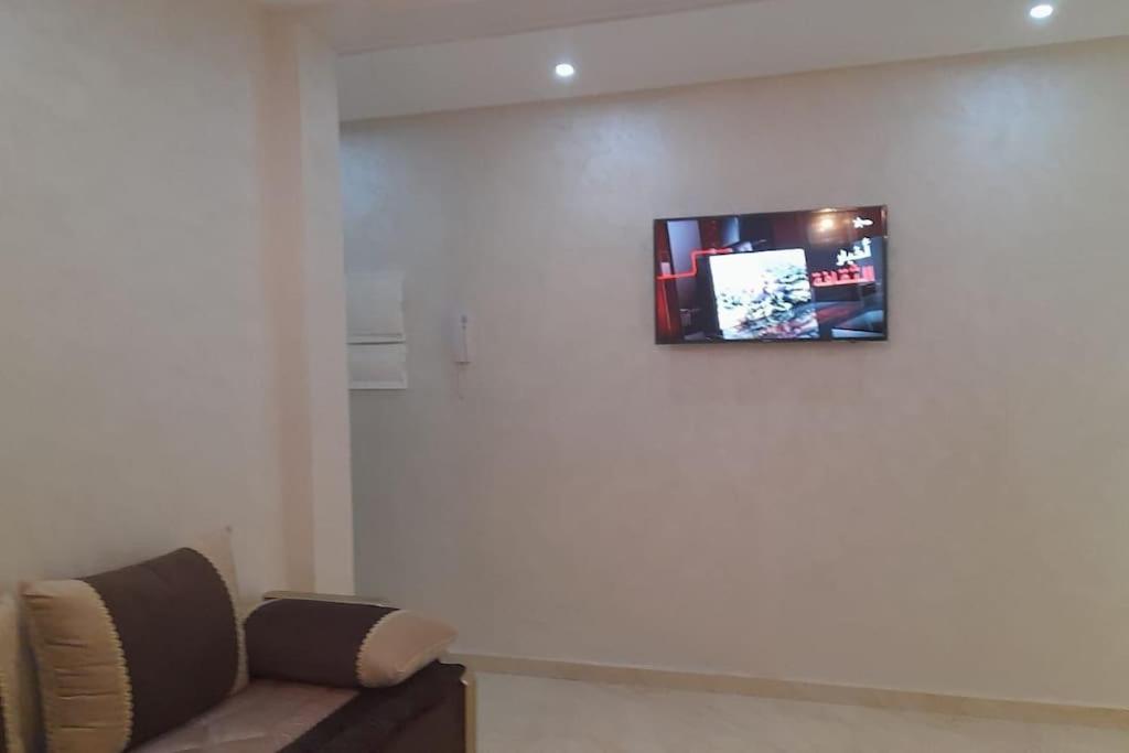 ein Wohnzimmer mit einem Sofa und einem TV an der Wand in der Unterkunft Apartment in Nador in Nador