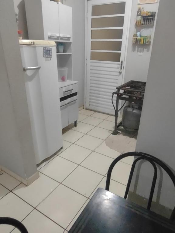 a kitchen with a refrigerator and a table at Casa RibeirãoPreto in Ribeirão Preto