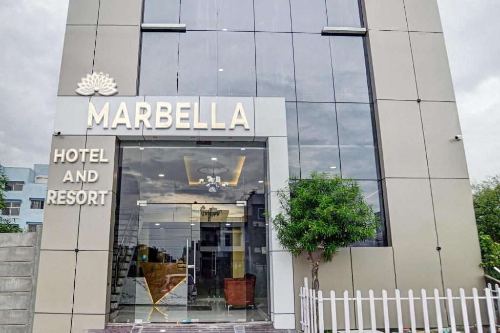 インドールにあるCollection O Marbella Hotelのホテルとリゾートを表示する看板のある建物