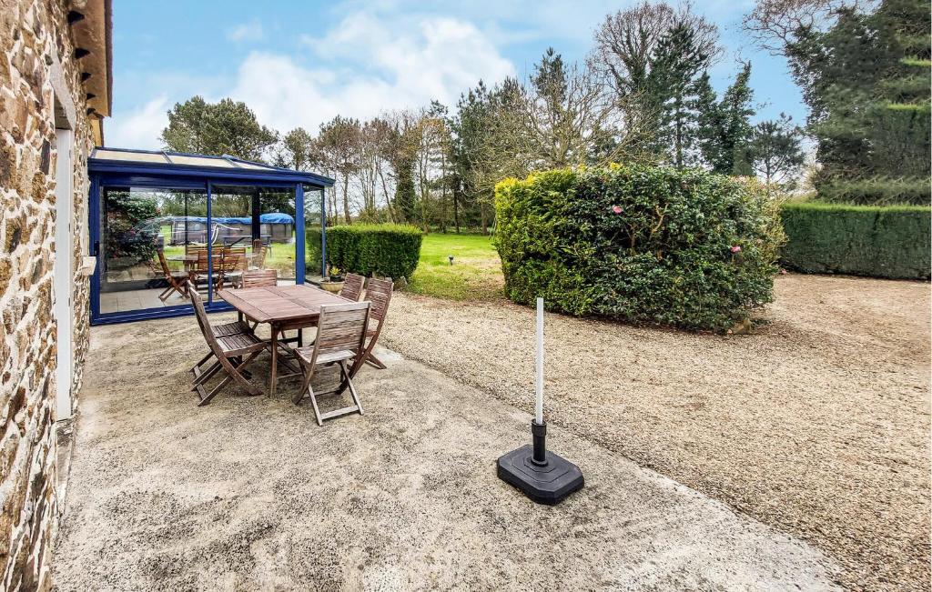une terrasse avec une table, des chaises et un parasol dans l'établissement 2 Bedroom Cozy Home In Plouha, à Plouha