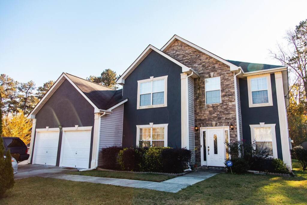 una casa nera con un garage bianco di Castle Comfort a Ellenwood