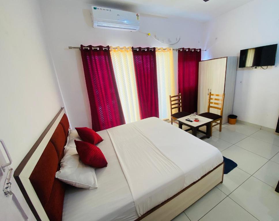 a bedroom with a large bed with red pillows at Hotel Heartwood City Corbett in Rāmnagar
